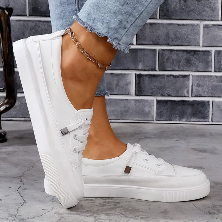Lace-up women's flatform sneakers, classic style. Comfortable, versatile court shoes in white for casual wear.