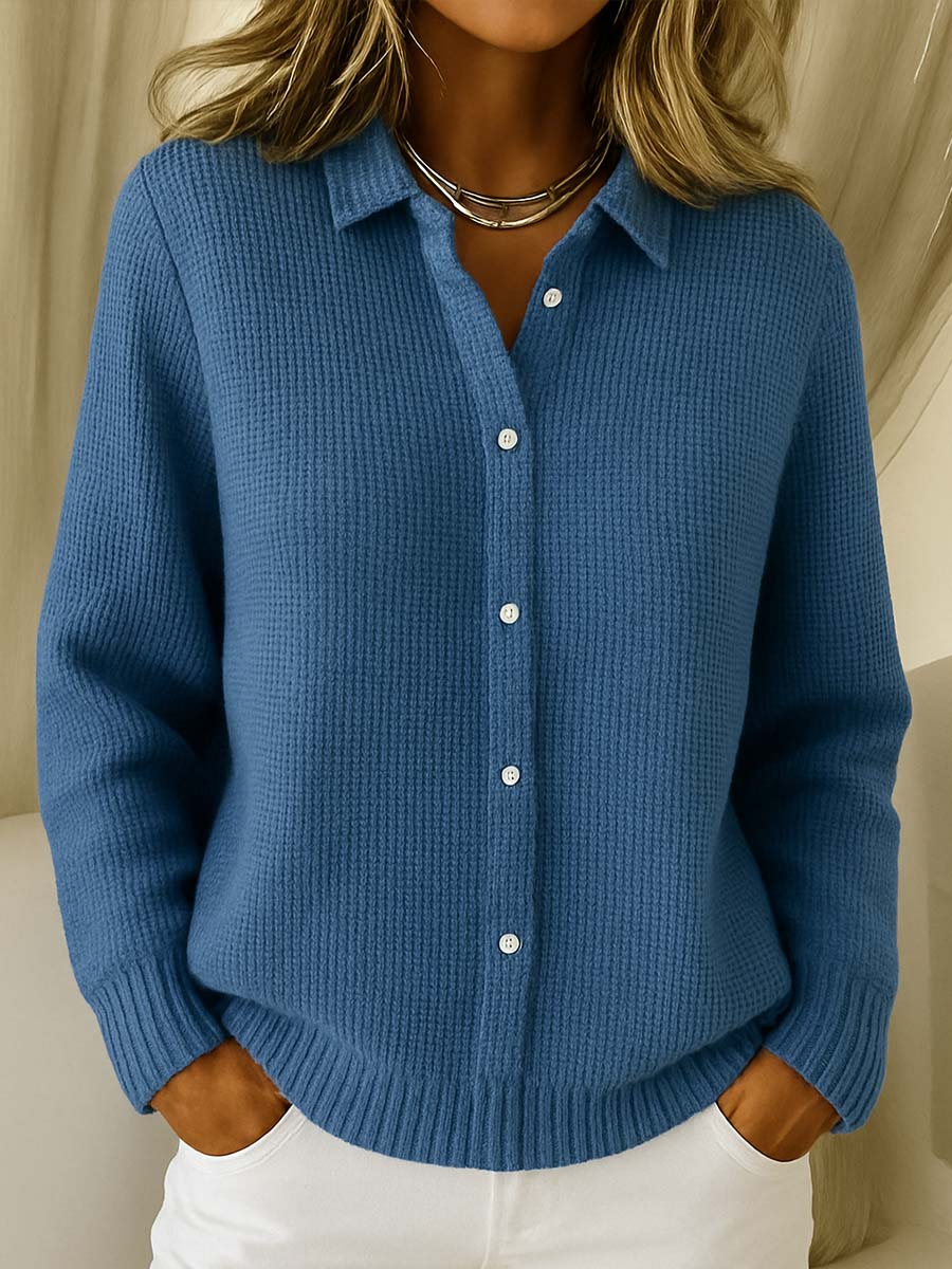 Close-up of a women's knit cardigan sweater, featuring ribbed collar and functional button-up front.