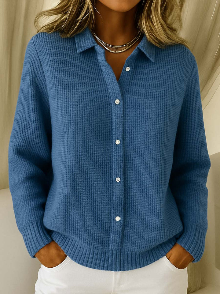 Close-up of a women's knit cardigan sweater, featuring ribbed collar and functional button-up front.