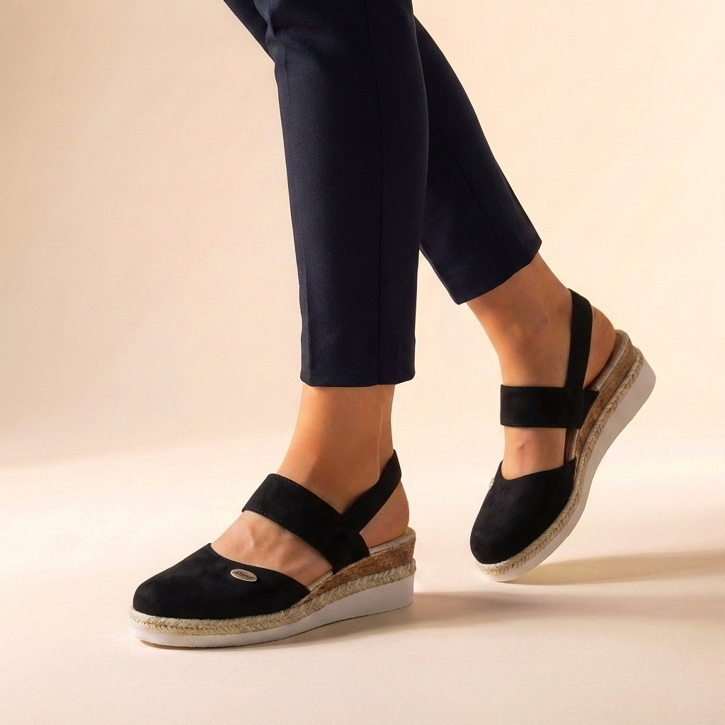 Women's slip-on espadrille platform sandals, worn for beachwear or casual outings, providing summer comfort & style.