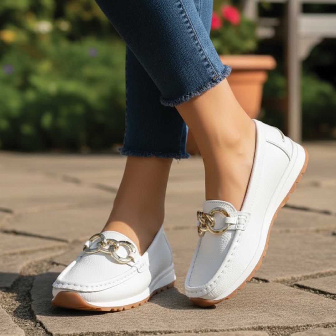 Detail of a gold buckle on women's black flat loafers, offering classic style & everyday comfort.