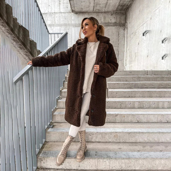 Stylish women's longline teddy coat with soft, cozy faux shearling texture. Ideal fall/winter outerwear for warmth & comfort.