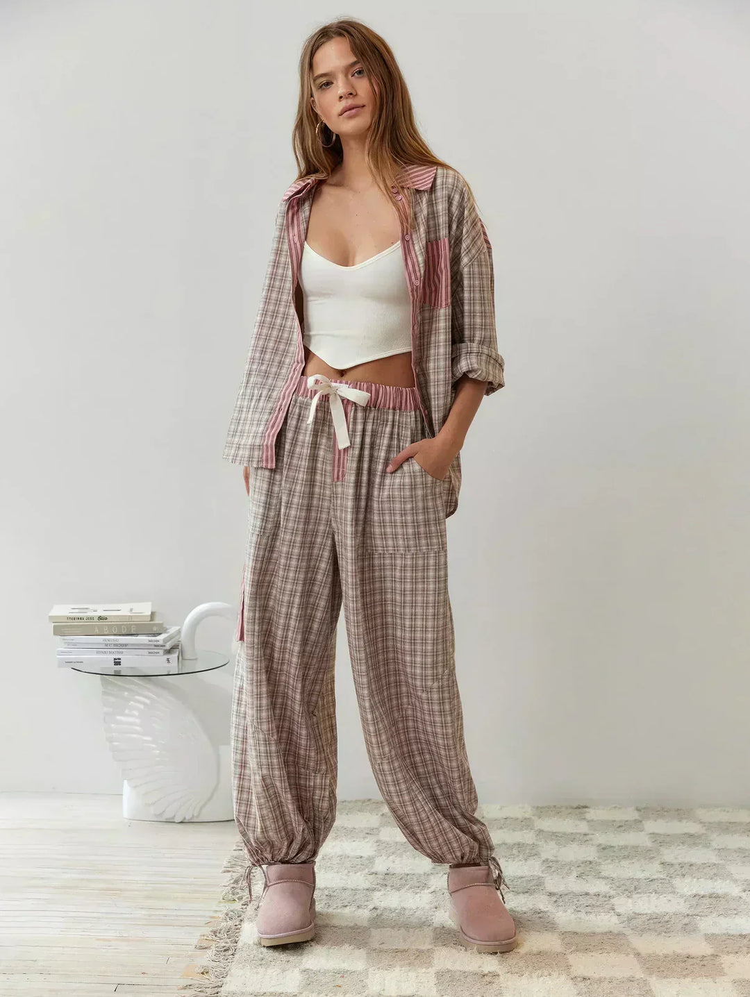 Woman wearing comfortable plaid button-up pajama set. Cozy loungewear for relaxed home moments.