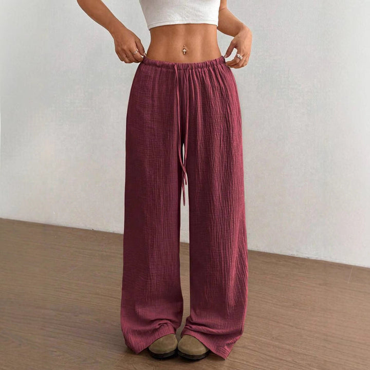 Model in women's wide leg crinkle pants, drawstring waist, showcasing flowy silhouette & relaxed fit.