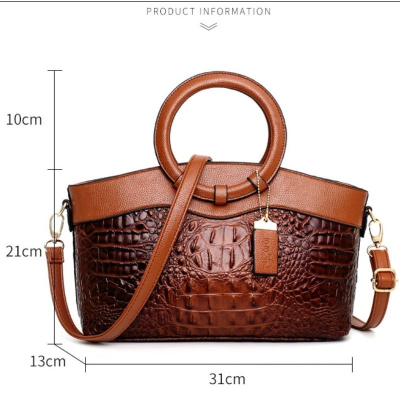 Detailed shot of the round handle on a women's vintage croc embossed faux leather handbag.