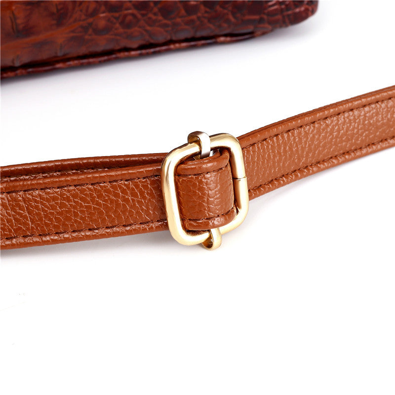 Close-up of the faux leather croc embossing on a women's vintage handbag, round handle visible.