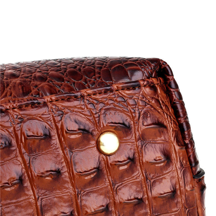 Luxury women's vintage shoulder bag, croc embossed, with a sleek round handle and elegant design.