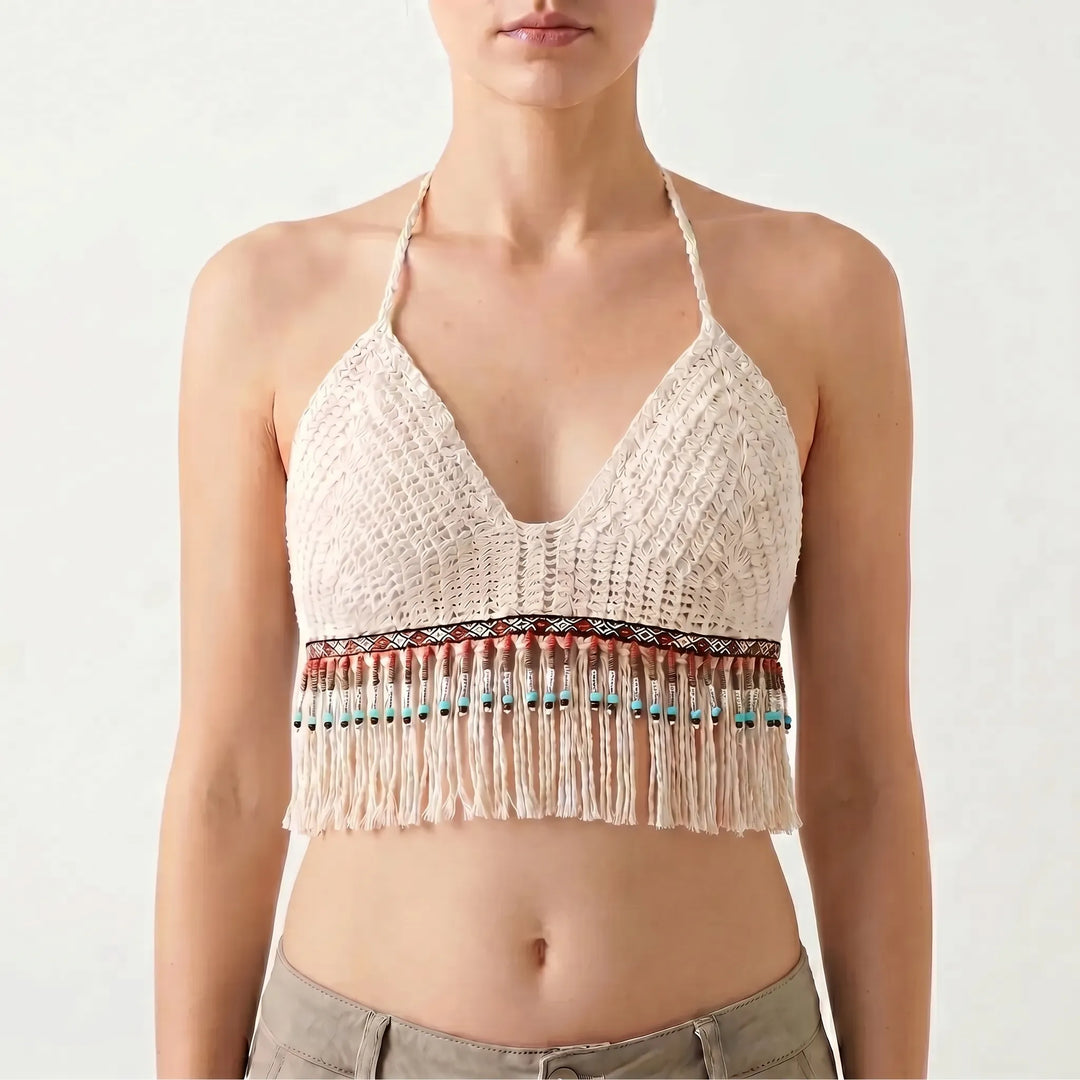 Sleeveless women's white crochet halter crop top with bohemian fringe detail for summer fashion.