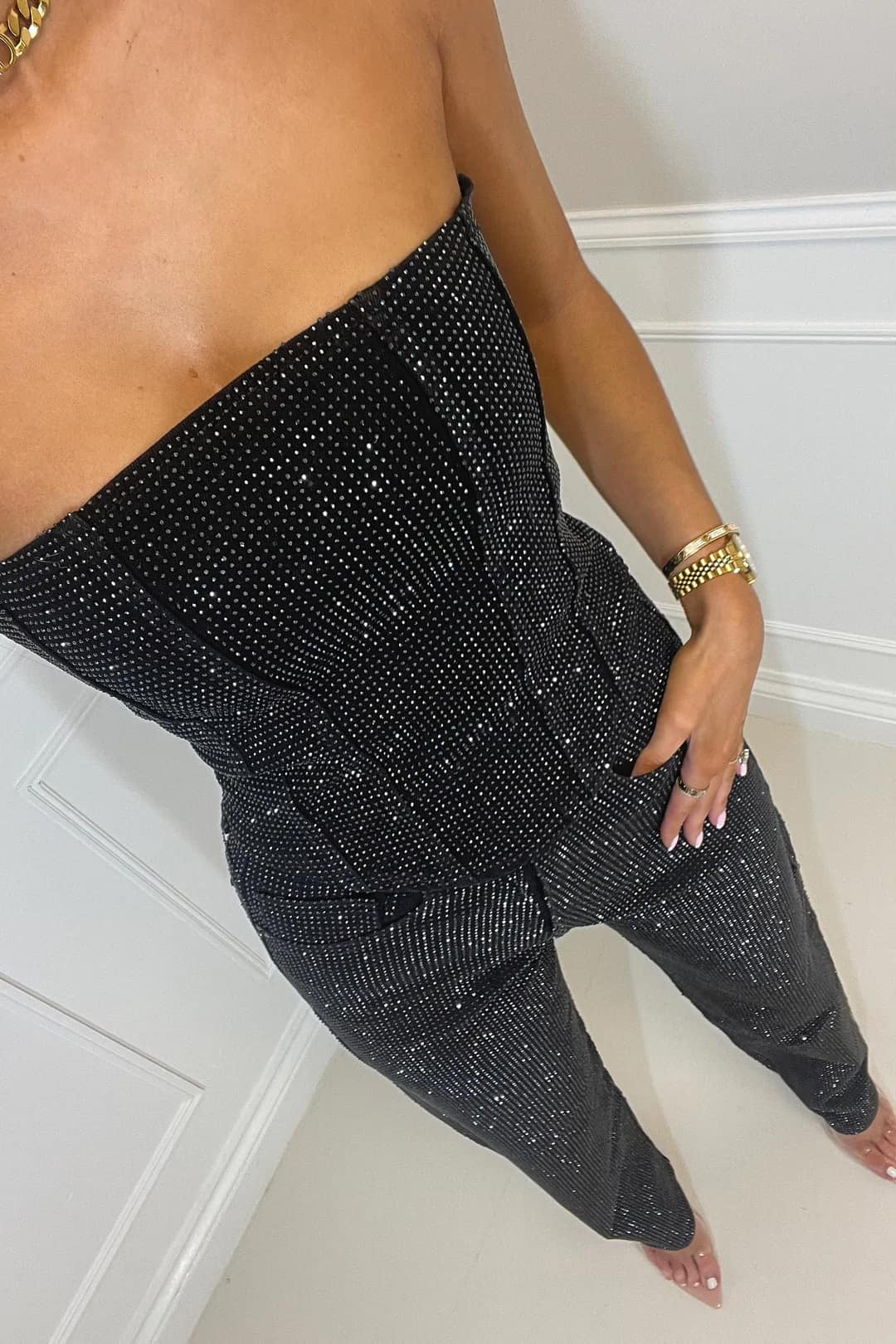 Back view of women's glitter crop top & high-waist jeans set. Stylish evening wear.