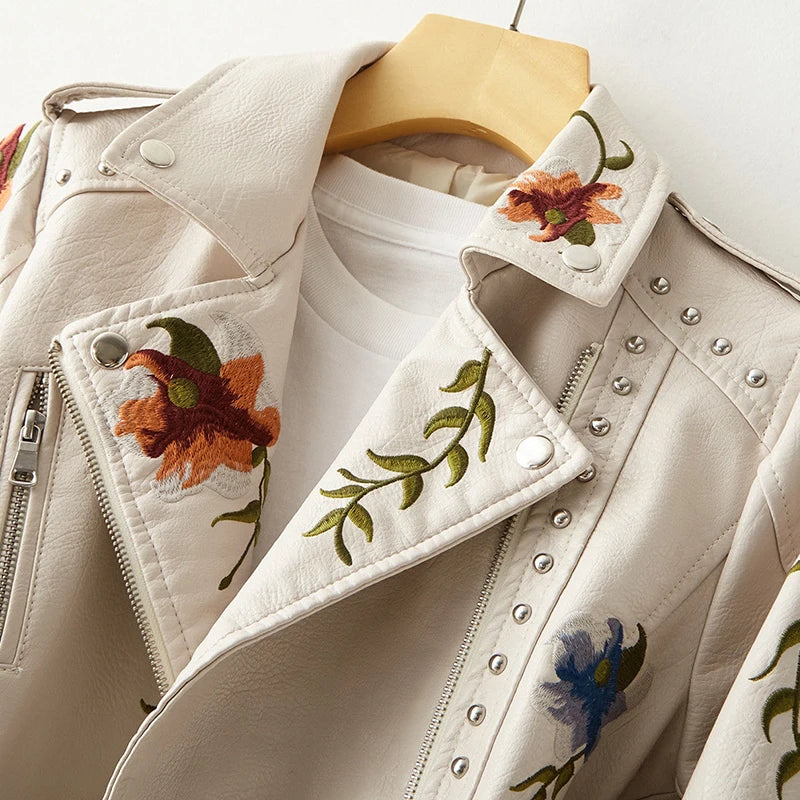 Women's black edgy jacket, featuring intricate floral embroidery & striking studs. A bold fashion outerwear.