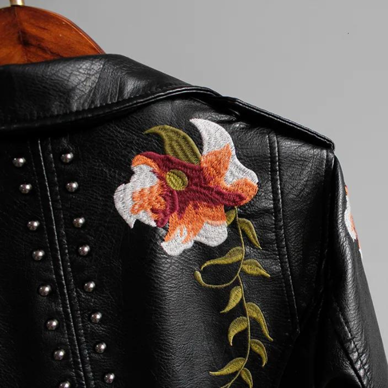 Edgy women's black studded jacket with floral embroidery. Biker style statement piece.