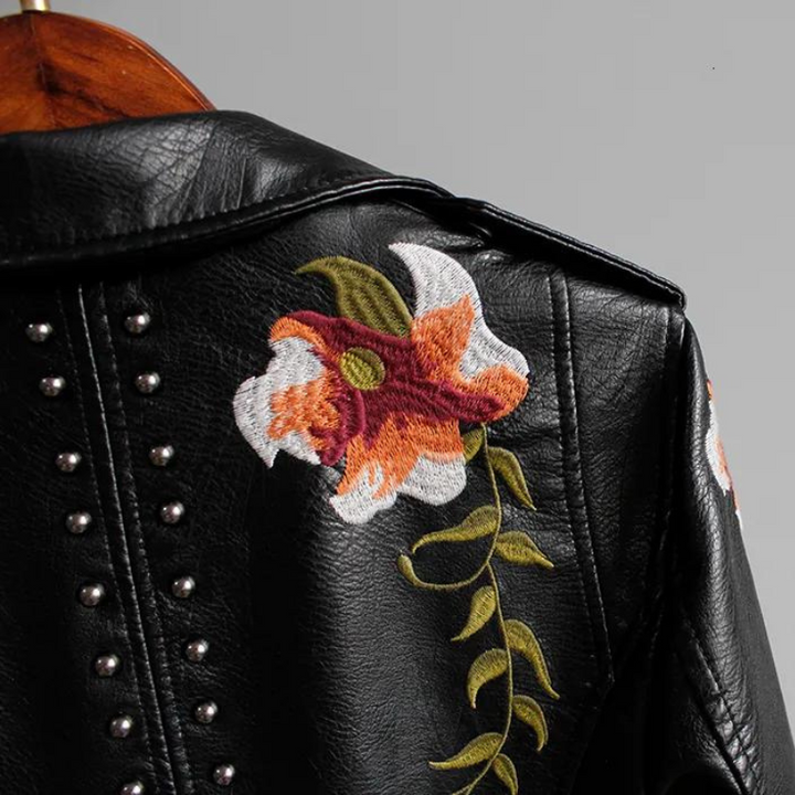 Edgy women's black studded jacket with floral embroidery. Biker style statement piece.