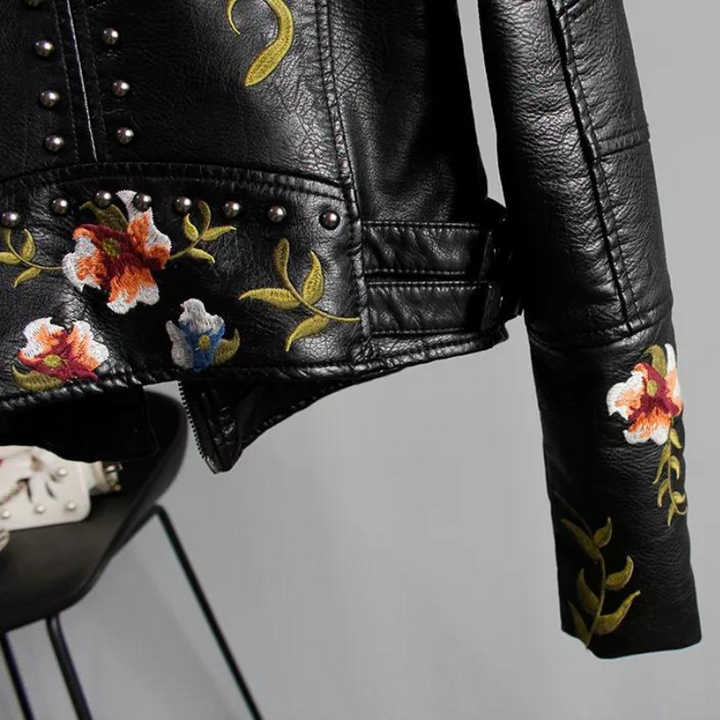 Women's edgy studded biker jacket, black with detailed floral embroidery. A chic fashion statement.
