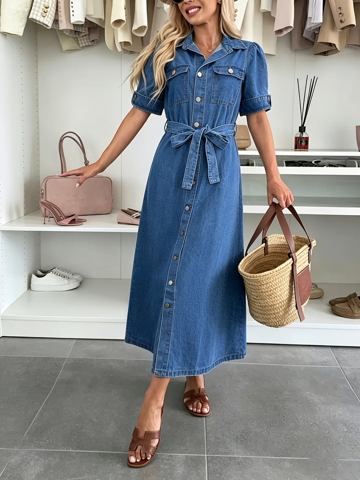Detail of women's blue button-front dress: close-up of buttons, belted waist, and subtle puff sleeves. Chic & casual.