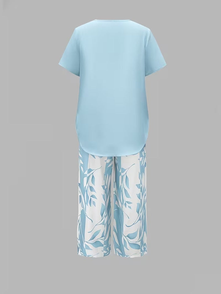 Woman walking in a stylish leaf print two-piece set: short sleeve top & cropped pants. Ideal summer fashion.
