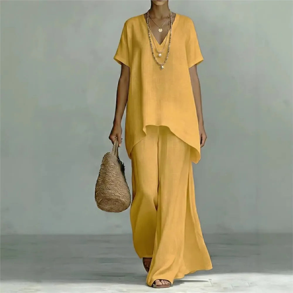 Woman wearing a comfortable linen blend two-piece set, featuring wide leg pants and an asymmetrical top for summer.