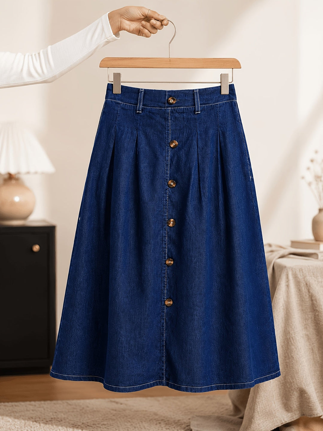 Stylish women's medium blue A-line denim midi skirt. Features button front detail & comfortable pleated design.