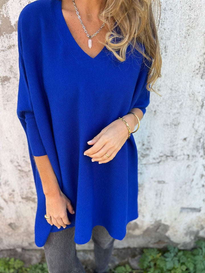 Comfortable women's batwing sleeve V-neck tunic pullover. Versatile, oversized sweater for casual fashion.