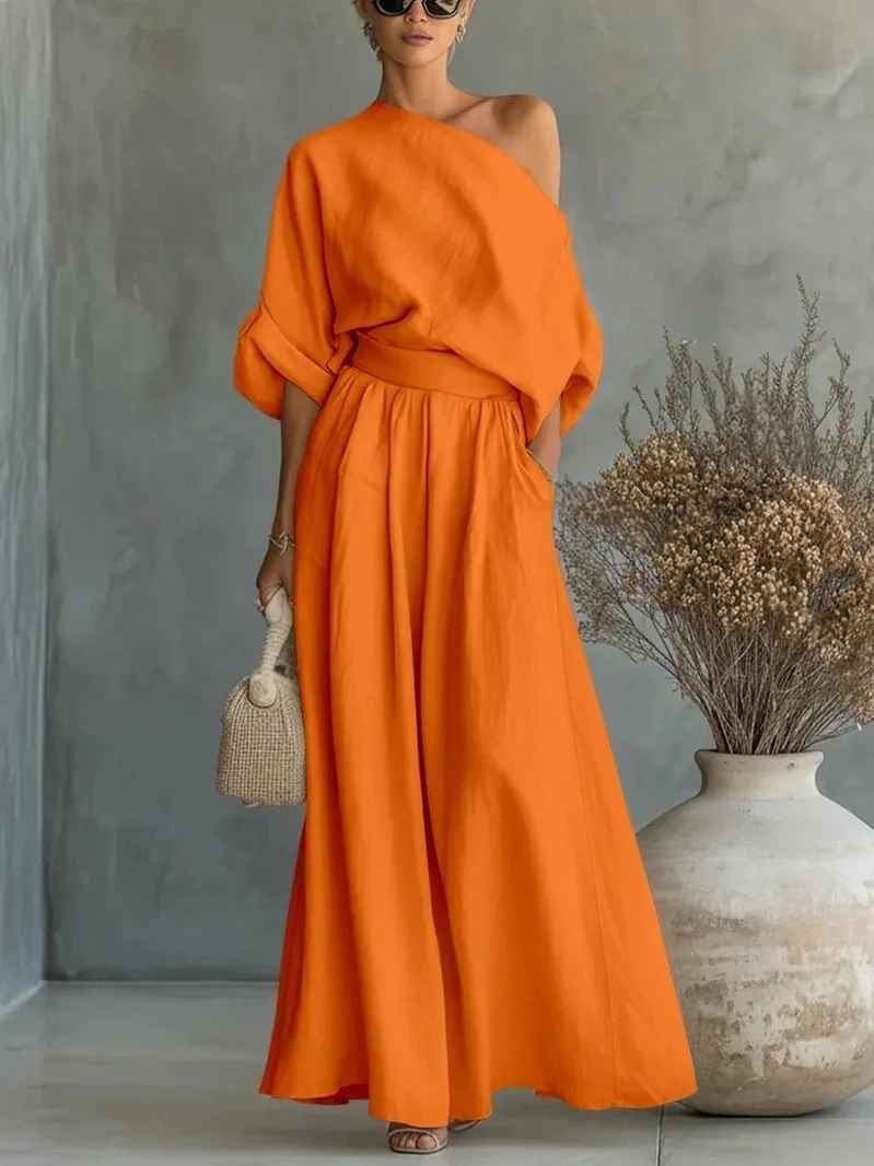 Model in motion: Chic women's two-piece pant set with asymmetric drape top & tapered pants, a versatile resort wear outfit.