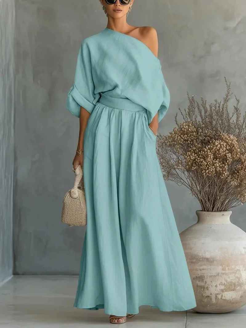 Folded product: Elegant women's two-piece pant set, an asymmetric drape top & tapered pants for a sophisticated vacation look.
