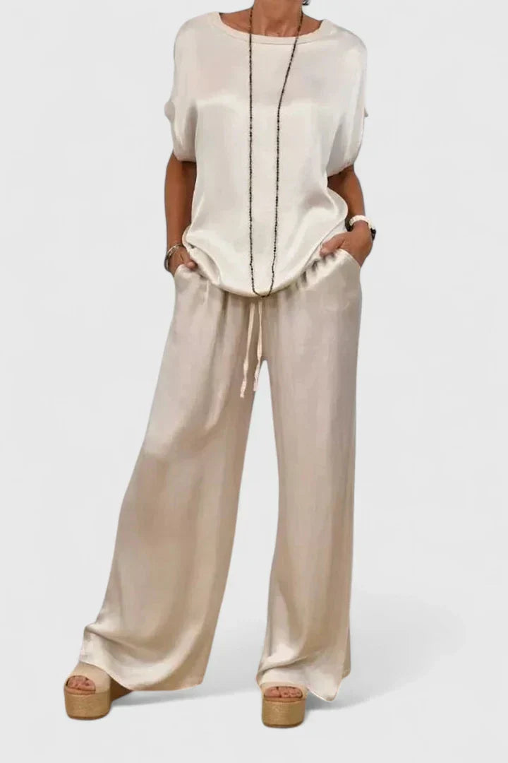 Fashionable woman modeling a versatile batwing top & wide leg pant matching set, suitable for evening or day wear.