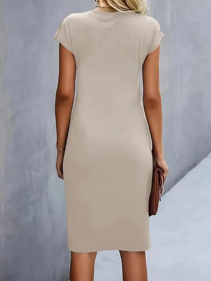 Woman wearing a graceful elegant midi dress, round neck, showcasing its versatile silhouette.