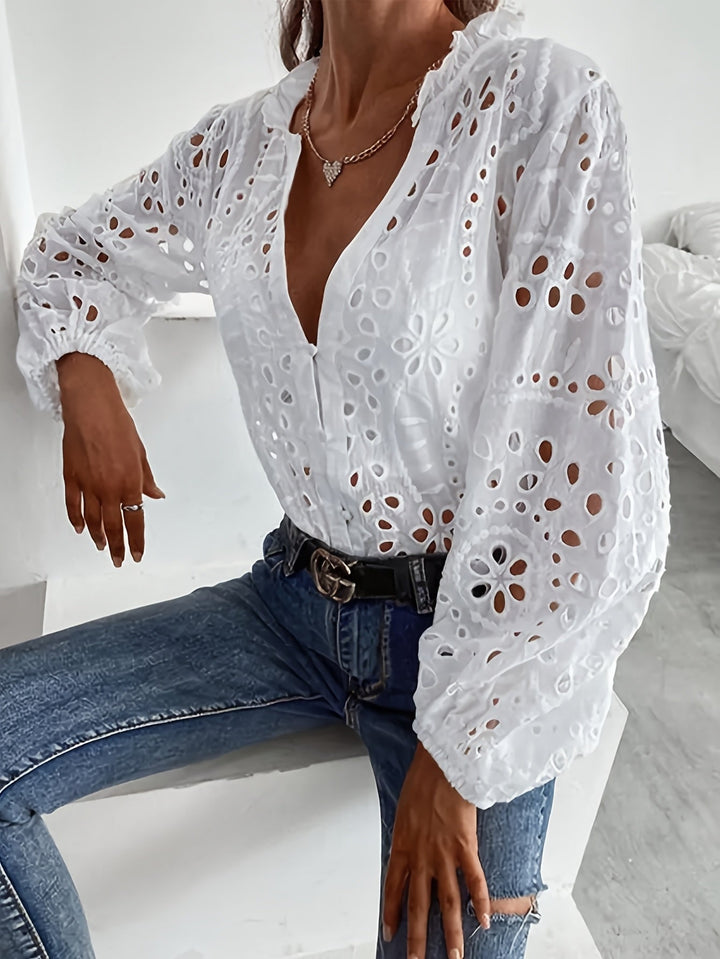 Detailed women's long-sleeve floral embroidered blouse, featuring elegant design and button-up front.