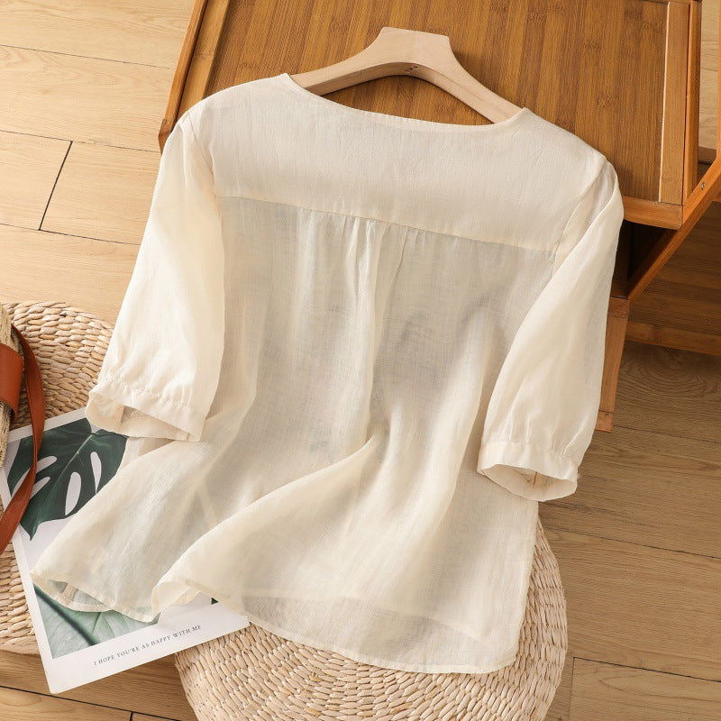 Model wearing a women's long sleeve floral blouse. Relaxed fit, V-neck, and elegant embroidery for versatile styling.