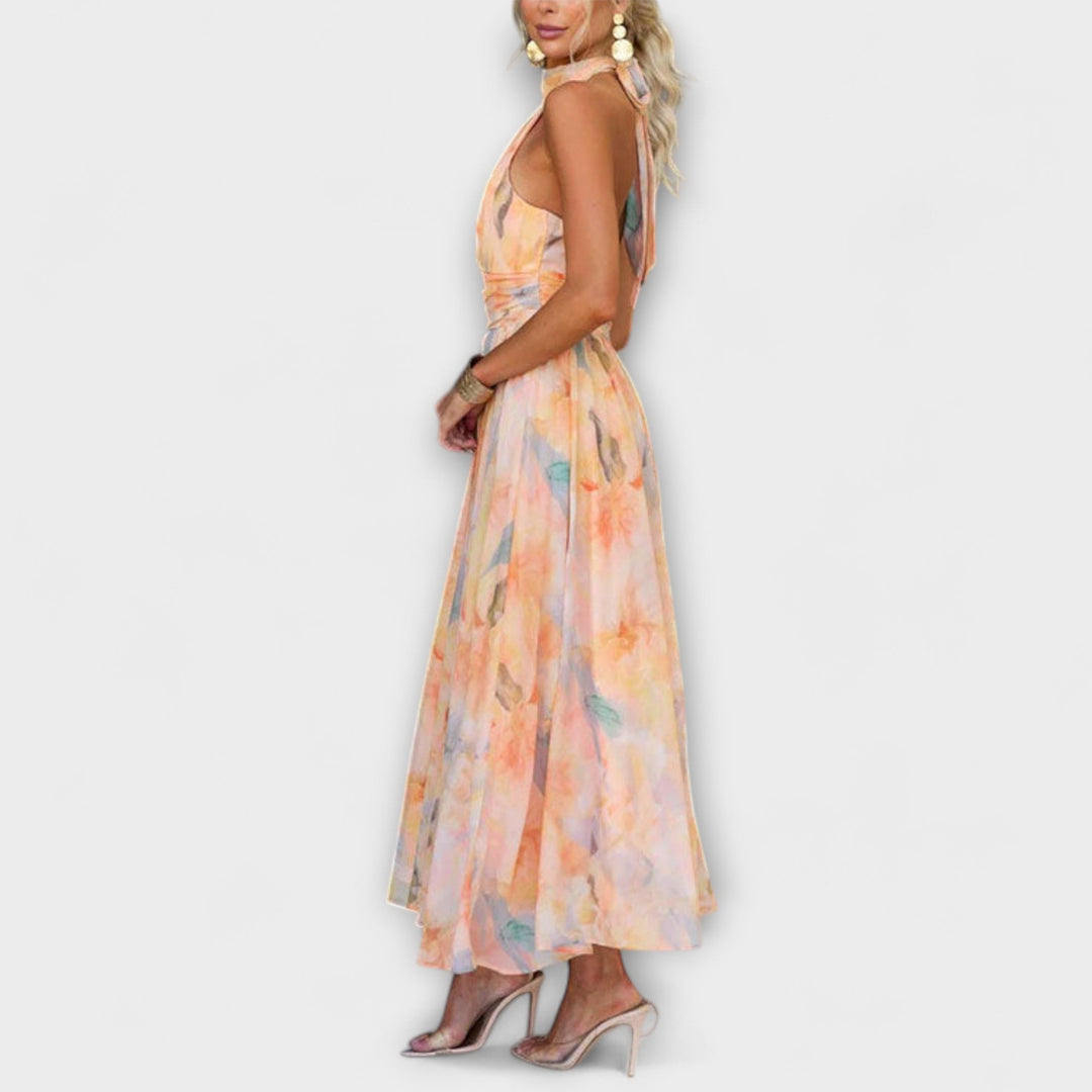 Flattering women's halter neck maxi dress with open back and watercolor print, ideal for chic summer occasion wear.