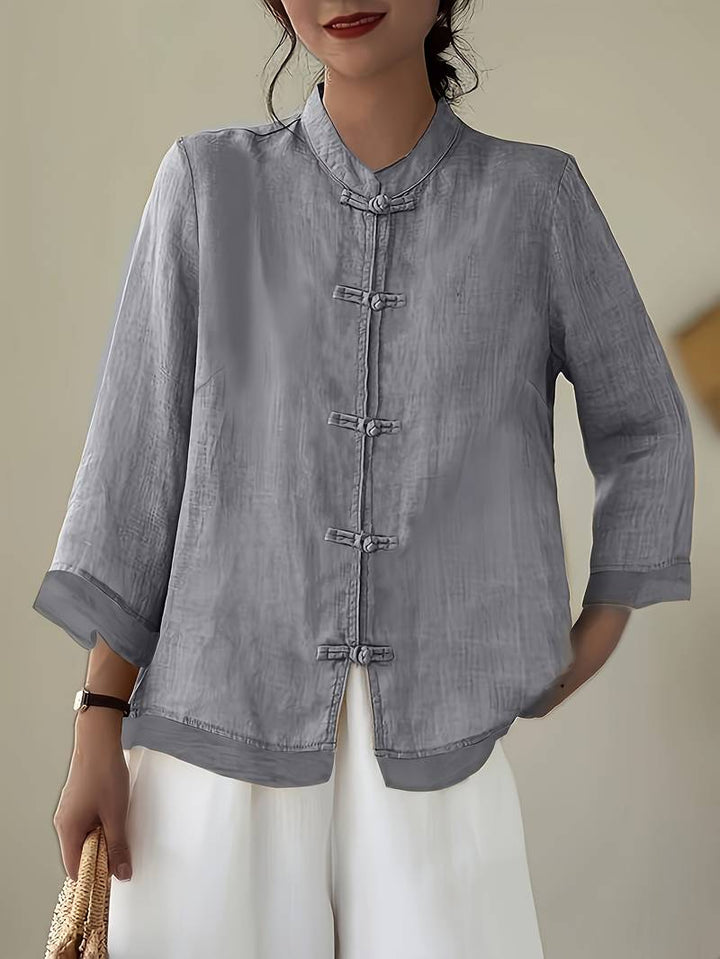 Tailored fit women's three-quarter sleeve blouse with elegant mandarin collar and frog buttons.