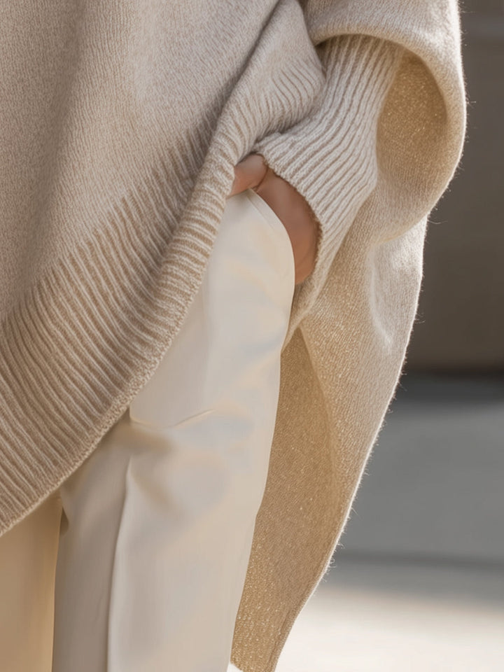 Model wearing an elegant oversized women's cape sweater poncho, showcasing fall fashion & chic comfort.