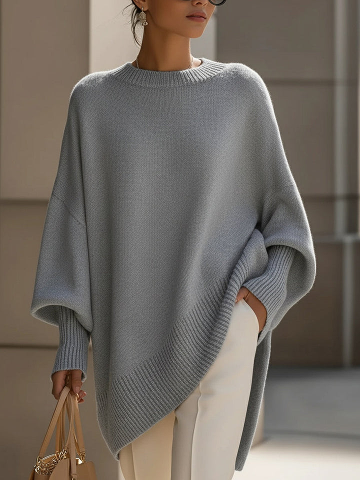 Woman enjoying fall weather in a cozy oversized cape sweater poncho, exuding comfortable elegance.