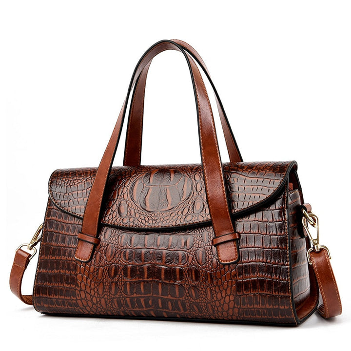Close-up of a women's elegant shoulder bag, highlighting the detailed crocodile texture and embossed design.