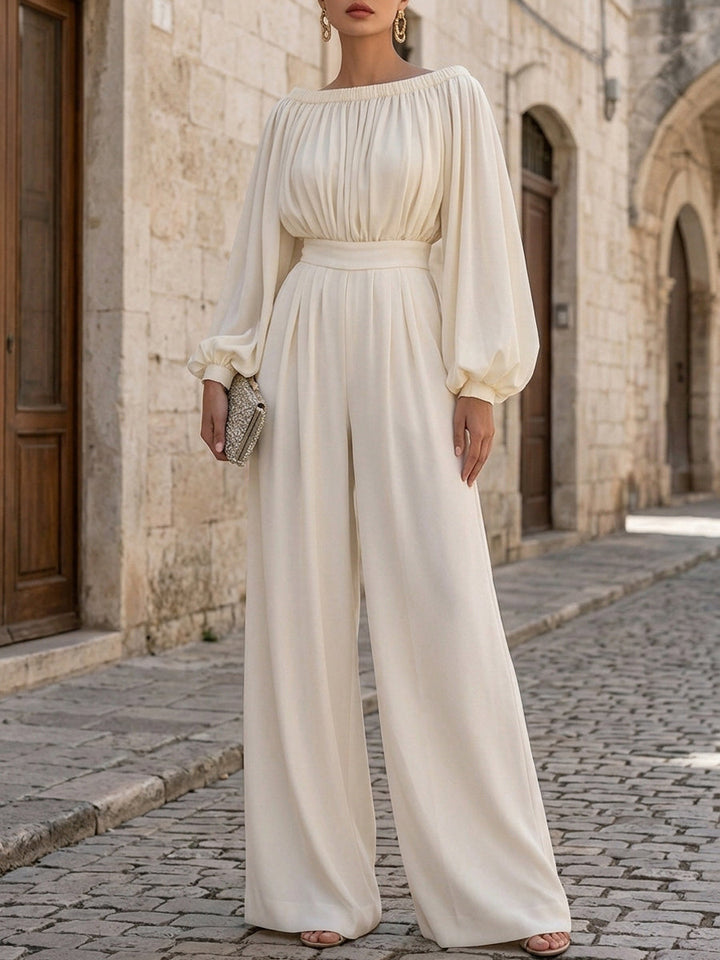 Flowing bishop sleeves on a white off-shoulder maxi dress, accentuating its elegant and romantic design.