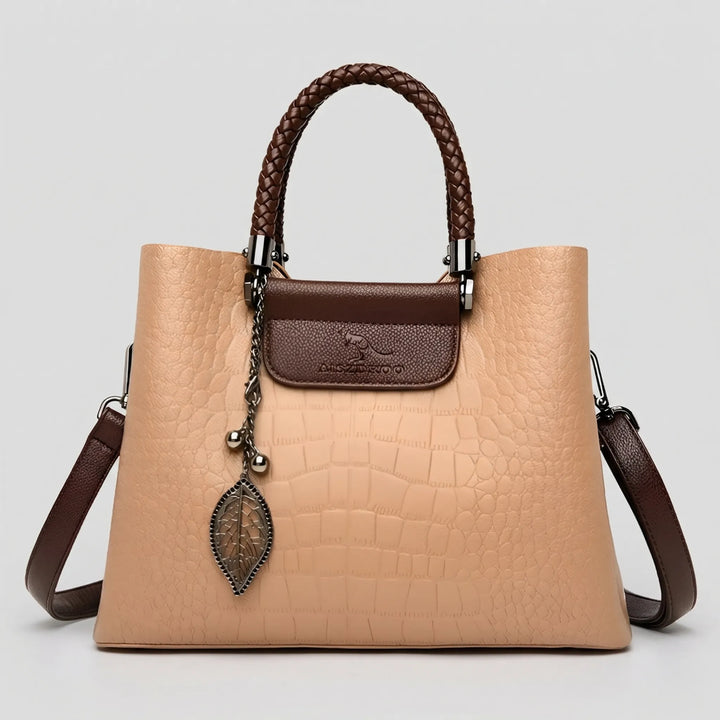 Elegant women's embossed pattern tote bag featuring a distinctive braided handle. Fashionable and practical shoulder bag.
