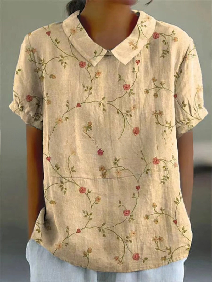 Model wearing a relaxed fit women's embroidered floral blouse with a charming Peter Pan collar.