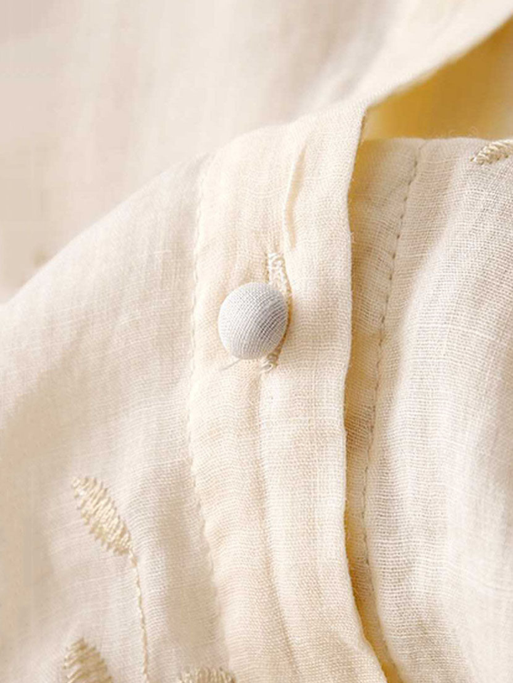 Chic women's embroidered long-sleeve top, button-front closure, round neck, ideal for spring fashion.