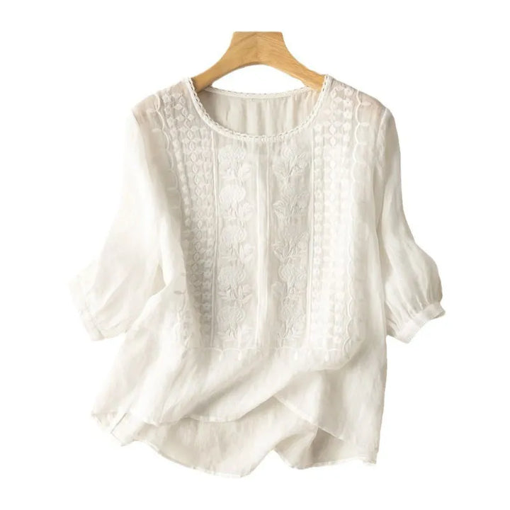 Women's embroidered puff sleeve blouse with floral design, round neck, and three-quarter sleeves.