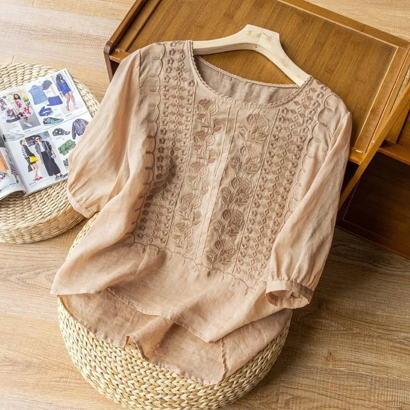 Stylish women's puff sleeve blouse with intricate floral embroidery & three-quarter sleeves for spring.