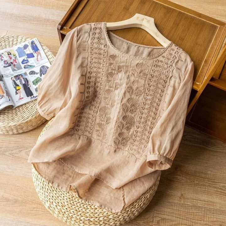 Stylish women's puff sleeve blouse with intricate floral embroidery & three-quarter sleeves for spring.