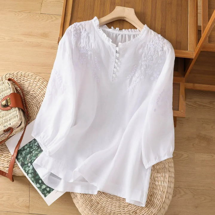 Feminine women's blouse with delicate embroidery, short sleeves, and a relaxed fit, ideal for everyday wear.
