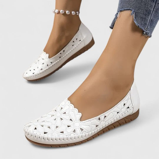 Close-up of floral cutout detail on comfortable women's slip-on ballet flats with scalloped edge.