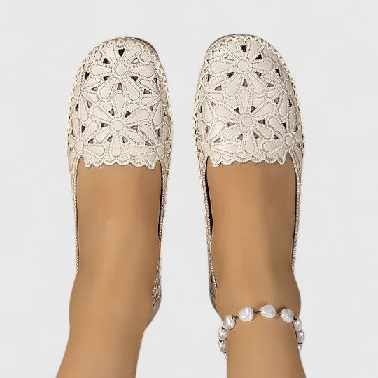 White round toe ballet flats for women, featuring floral cutouts and comfortable slip-on design.