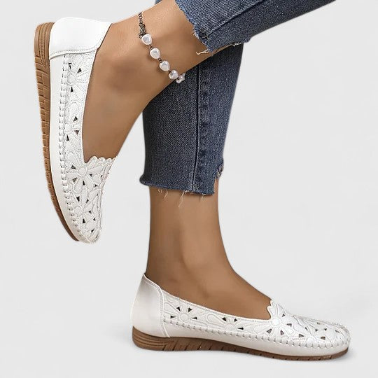 Perforated women's ballet flats with elegant floral cutouts and comfortable slip-on style.