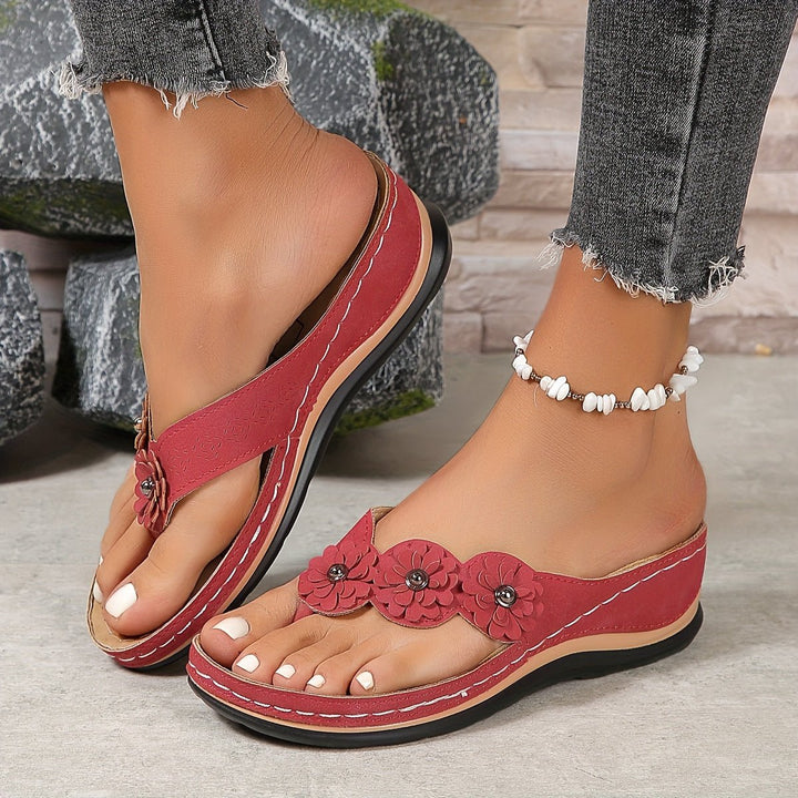 Women's platform wedge sandals with vibrant floral print. Comfortable slip-on summer footwear.