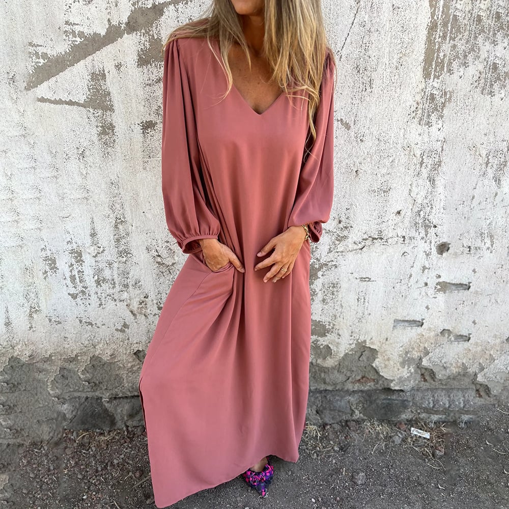 Woman wearing a comfortable flowy maxi dress with balloon sleeves and pockets, suitable for day or evening wear.