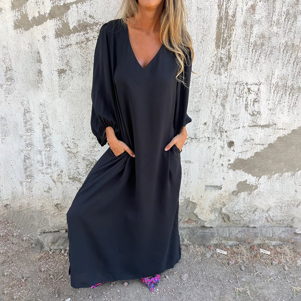Close-up of the elegant V-neck and comfortable balloon sleeves on a women's flowy maxi dress with pockets.