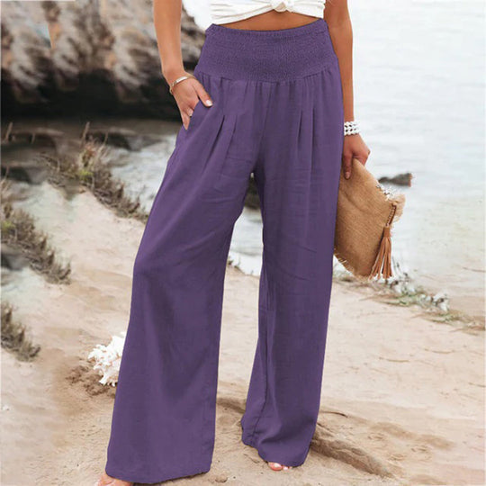 Back view of women's flowy wide leg summer pants, featuring elastic waist and elegant relaxed drape.