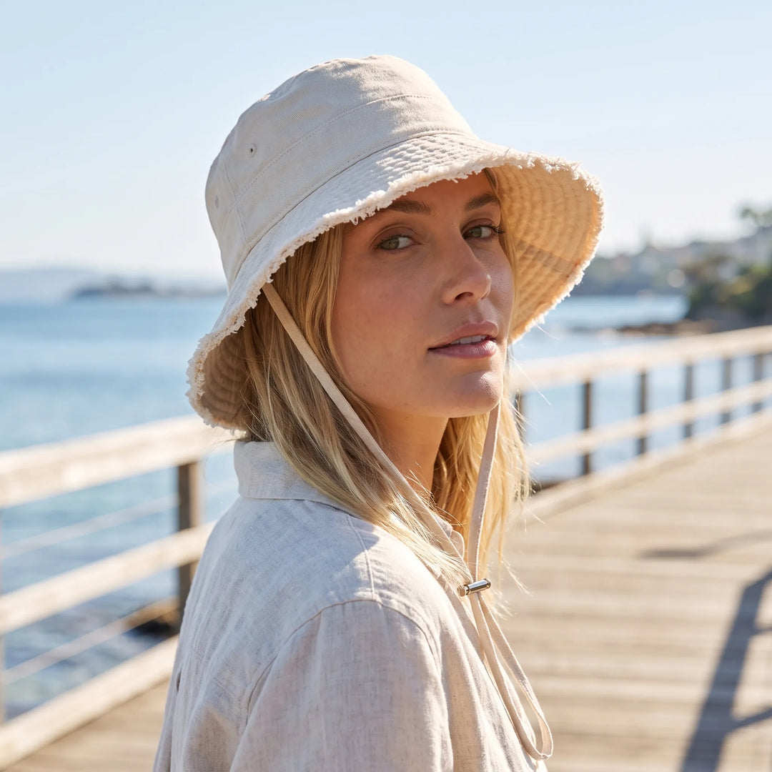 Women's frayed brim bucket hat, adjustable for summer sun protection.
