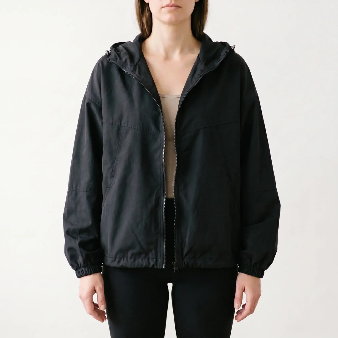 Stylish women's full-zip hooded windbreaker jacket, ideal for layering and casual wear during spring and fall.